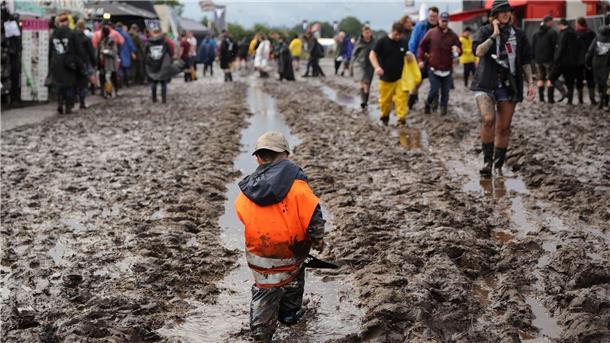 Kleine und große Heavy-Metal-Fans versinken beim Wacken im Matsch.