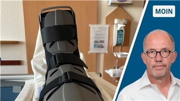 Ein Fuß in einer Orthese im Krankenhausbett.