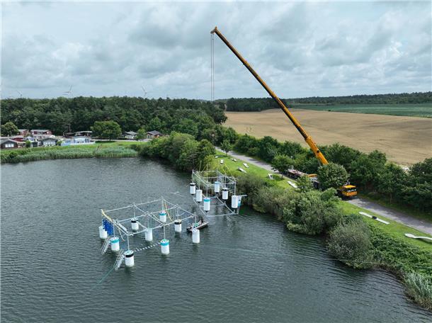Kletterpark am Haken: Mit großem logistischen Aufwand wurde am Dienstag der vormontierte Aqua Chimp in den Kransburger See gehoben.