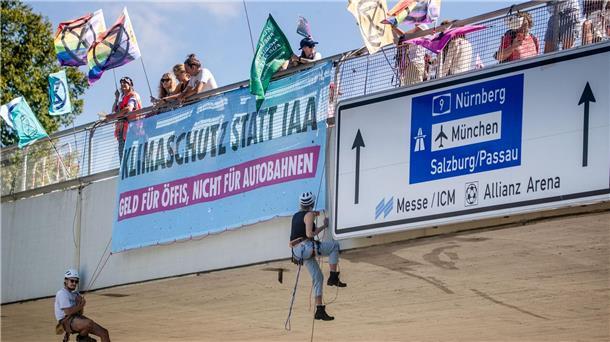 IAA-Gegner sorgen mit Abseilaktion für Stau in München Klimaaktivisten von Extinction Rebellion seilen sich in München von einer Brücke ab.