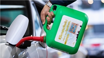 „Klimaschutz könnte man Tanken - E-Fuels for Future“: Ein Auto wird mit einem Kanister mit E-Fuel betankt.