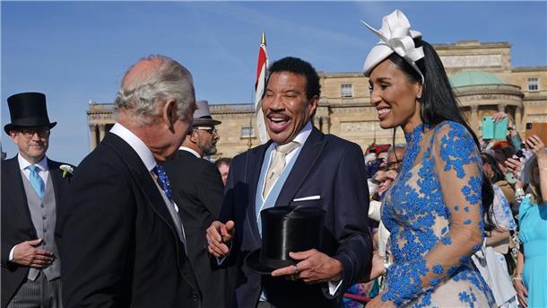 König Charles III. (l) spricht während der Gartenparty im Buckingham Palace mit Lionel Richie (M) und Lisa Parigi.