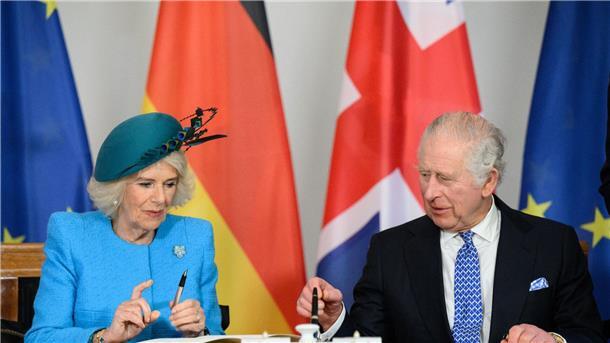 Jubelrufe und Fähnchen: Charles und Camilla in Berlin König Charles III. und Königsgemahlin Camilla tragen sich im Schloss Bellevue ins Gästebuch ein.