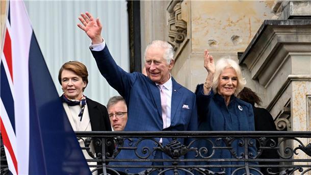 Hamburg bereitet Charles und Camilla jubelnden Empfang König Charles III. von Großbritannien (M) und Königsgemahlin Camilla (r) winken vom Balkon des Hamburger Rathauses.