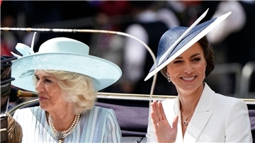 Königsgehmahlin Camilla und Prinzessin Kate fahren in einer Kutsche.