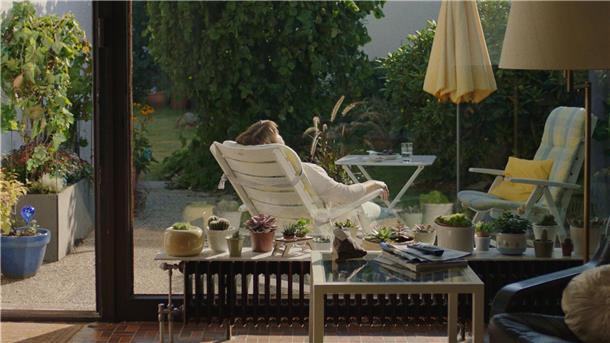 Konnie (Marion Ottschick) liegt im Liegestuhl auf der kleinen Veranda ihres Hauses.