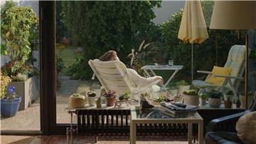 Konnie (Marion Ottschick) liegt im Liegestuhl auf der kleinen Veranda ihres Hauses.