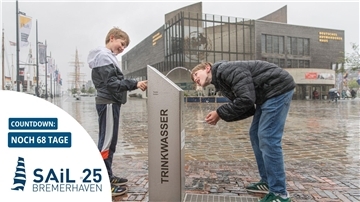 Zwei Jungs bedienen sich am Trinkwasser-Spender am Neuen Hafen.