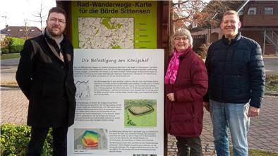Kreisarchäologe Dr. Stefan Hesse übergibt Stefan Miesner und Erika Jaschinski eine Tafel zur Befestigung beim Königshof.