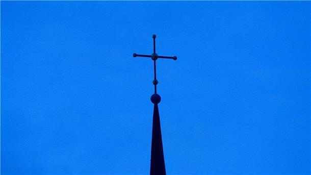 Kritik an Umgang mit Missbrauch in evangelischer Kirche Kreuz einer evangelisch-lutherischen Kirche in der Abenddämmerung.