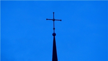 Kreuz einer evangelisch-lutherischen Kirche in der Abenddämmerung.