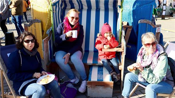Vier Personen essen Kuchen und trinken Kaffee