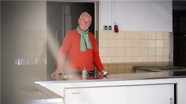 Mann hinter einer Küchenzeile.