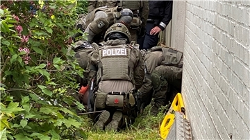 Kurz nachdem der 37-Jährige durch das geschlossene Fenster aus dem ersten Stock des Hauses gesprungen ist, wird der Verletzte von SEK-Beamten am Boden fixiert.