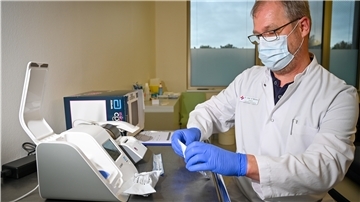 Labormediziner Dr. Bernd Wolters zeigt das kleinere Gerät für die schnelle PCR-Test-Variante. Auch dafür muss ein Rachenabstrich genommen werden. Der PCR-Test kann auch geringe Virusmengen nachweisen. Das kann der Antigentest, der an einen Schwangerschaftstest erinnert, nicht so zuverlässig.