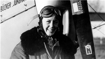 Lächelnd steht Beate Uhse in Fliegermontur vor einem Flugzeug. Beate Uhse war eine der bekanntesten deutschen Frauen des vergangenen Jahrhunderts.