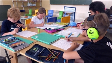 Vier Schüler an zwei Tischen