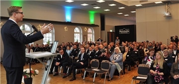 Mann spricht vor Zuhörern in einem Saal.