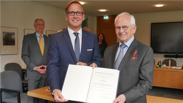 Landrat Stephan Siefken (links) überreicht Manfred Wolf, Mitglied des Kreistags des Landkreises Wesermarsch, das Bundesverdienstkreuz.