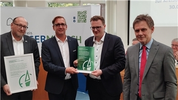 Landrat Stephan Siefken (Zweiter von links) überreicht den Innovationspreis im Beisein von Olaf Reichert (links) vom Powerhouse Nord und IHK-Präsident Jan Müller (rechts) an Tim Eshold als Sprecher der Wasserstoff-Allianz.