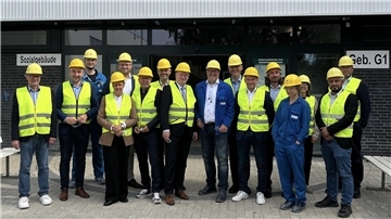 Gruppenfoto mit Menschen, die gelbe Westen und gelbe Helme tragen. Landtagsabgeordnete informierten sich in Nordenham über die Lage bei Kronos. Themen waren steigende Kosten durch Sedimente sowie die Hürden beim Bau einer Solaranlage: im blauen Sakko Kronos-Werkleiter Carsten Büsing sowie rechts neben ihm Björn Thümler (CDU) und Stefan Klein (SPD).
