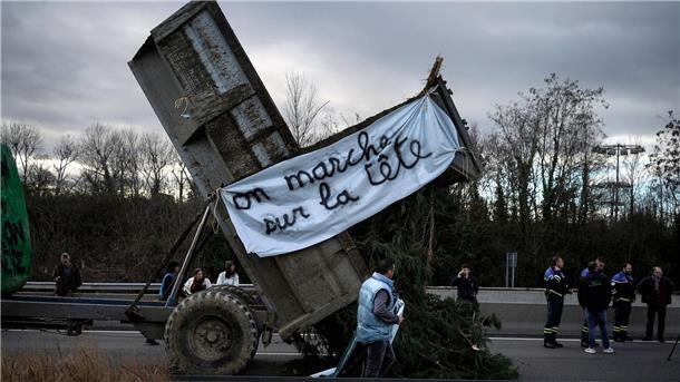 Frankreichs Bauern wollen Druck mit Protestaktionen erhöhen Landwirte kippen Zweige und Äste auf die Fahrbahn, während sie eine Autobahn in der Nähe von Lyon blockieren.