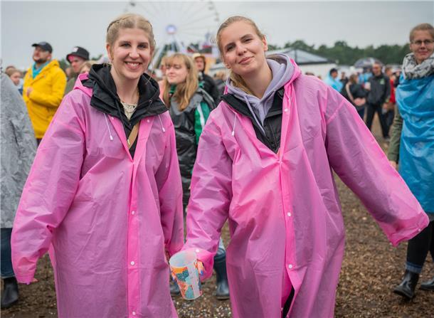 Deichbrand 2023 ertrinkt: REGEN und SCHLAMM ohne Ende (Fotos) Lara und Annika tragen eine besonders stylishe, pinke Variante der üblichen Regen-Capes.