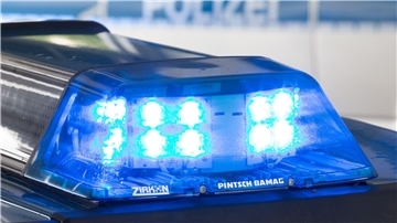 Ein Blaulicht leuchtet auf dem Dach eines Polizeiwagens.