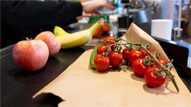 Umfrage: Wirtschaftliche Zuversicht schwindet Lebensmittel liegen in einem Supermarkt an der Kasse auf dem Band.