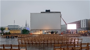 leere Stühle vor Kino-Leinwand