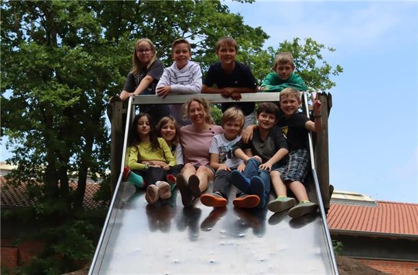 Wettbewerb zum Grundgesetz-Jubiläum: Tarmstedter Grundschüler gewinnen Preis Kinder sitzen mit ihrer Lehrerin auf einer Rutsche.