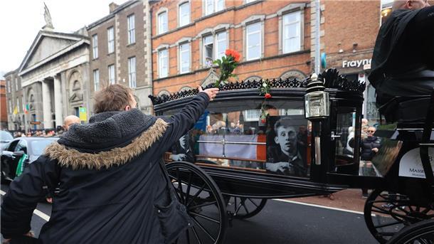Letzter Abschied: Passanten werfen Blumen auf den Leichenwagen.