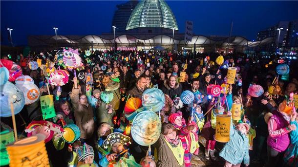 Buntes Laternenfest mit großem Umzug in Bremerhaven Kinder mit Laternen stehen im Halbdunkeln.