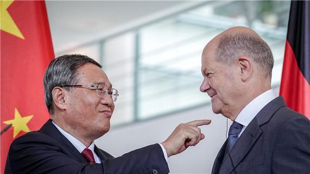 Scholz fordert mehr Druck Chinas auf Russland Li Qiang (l) zeigt zum Ende des Pressestatements auf den Kopfhörer für die Übersetzung im Ohr von Bundeskanzler Olaf Scholz.