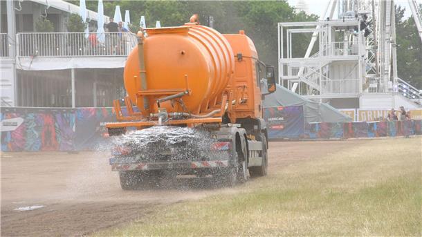 Lkw sind im Infield unterwegs, um das staubige Gelände vor dem Besucheransturm zu bewässern.