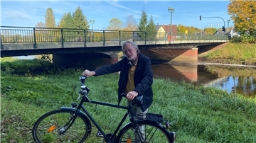 Lothar Tabery vor der Ostebrücke. Im Hintergrund sind die beiden Pfeiler zu sehen, um die es geht.