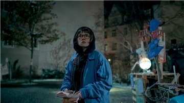 Luise Kogan (Lea Drinda) verteilt Flyerin einer Szene der Serie „Wer wir sind“.