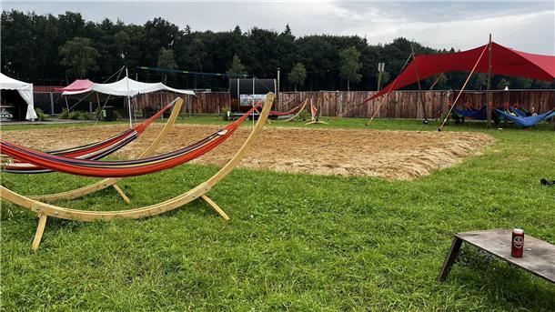 Ein Volleyballfeld und Hängematten. 