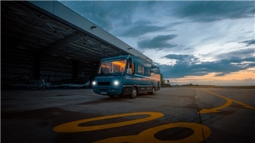Ein Bus steht auf einem Flugplatz in der Abenddämmerung.