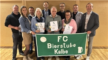 Männer und Frauen stehen in einer Gruppe zusammen.