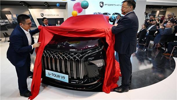 IAA spiegelt Autobranche: Selbstbewusste Chinesen Manager der Dongfeng Liuzhou Motor Co. Ltd. enthüllen auf der IAA ein neues Fahrzeug der Marke Forthing.