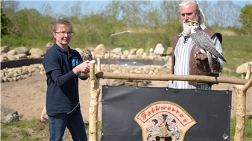 Mareike Sander (mit Steinkauz Felix) und Falkner Klaus Sander (mit Gerfalke Lela) wollen ihre Tiere auch den Campinggästen näherbringen. Im Hintergrund ist die gerade fertiggestellte Feuerstelle im Sandstedter Naturcamping-Bereich zu sehen.