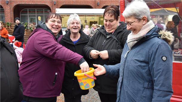 DAs Foto zeigt Marianne Baden mit Leuten auf dem Weihnachtsmarkt. 