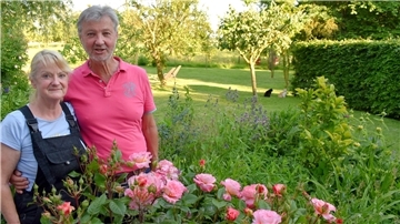 Marion und Mario Wagner-Hansen in ihrem weitläufigen Garten vor einem Strauch der Rose Augusta Luise.