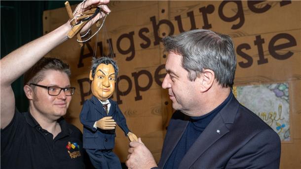 Marionettentheater bekommt mit Söder einen berühmten Paten Markus Söder (r, CSU), Ministerpräsident von Bayern, gibt in der Augsburger Puppenkiste einer Söder-Marionette die Hand.