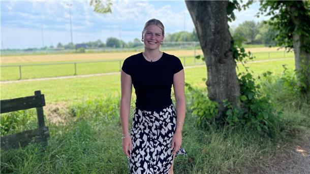 Frau vor einem Fußballfeld