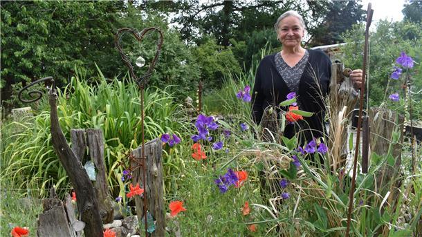 Eine Frau steht in ihrem Garten.