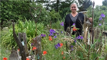 Eine Frau steht in ihrem Garten.