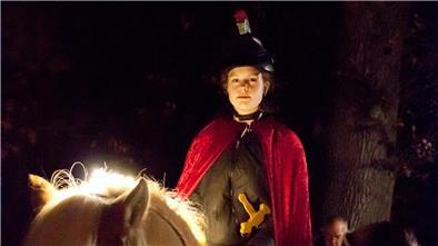 Frau in Mantel auf Pferd