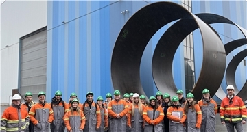Viele Männer und Frauen stehen vor den Werkshallen von Steelwind in Nordenham-Blexen.